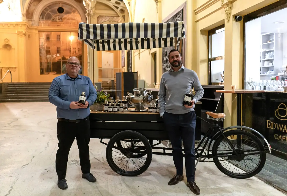 Štěpán Katina a David Folprecht s lahvemi Maria Liquer u vozíku Edward Café na kolonádě